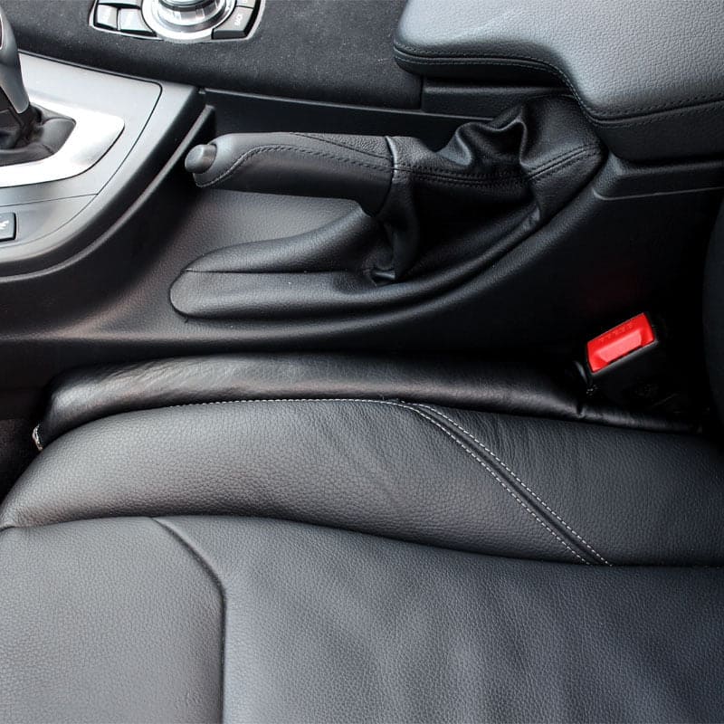 AutoSavvy GapGuard installed in a car, showing its effective design in black leather to prevent items from falling between the seats and the center console. Includes four color options: black, brown, gray, and beige. This cool car accessory enhances safety and organization, perfect for car hacks and maintaining a clean car interior.