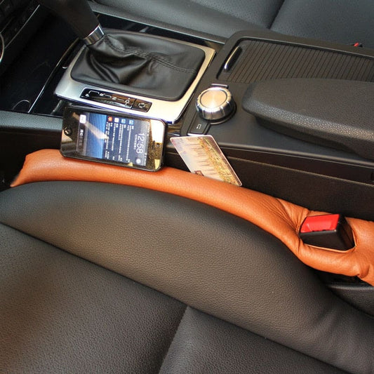 AutoSavvy GapGuard installed in a car, showing its effective design in brown leather to prevent items like a phone and cards from falling between the seats and the center console. Includes three color options: black, brown, and beige. This cool car accessory enhances safety and organization, perfect for car hacks and maintaining a clean car interior.